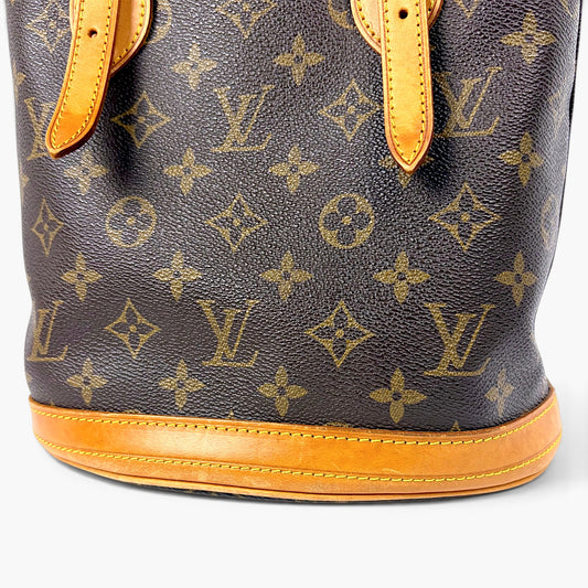 Monogram canvas bucket bag side with tan leather trim and stitched base