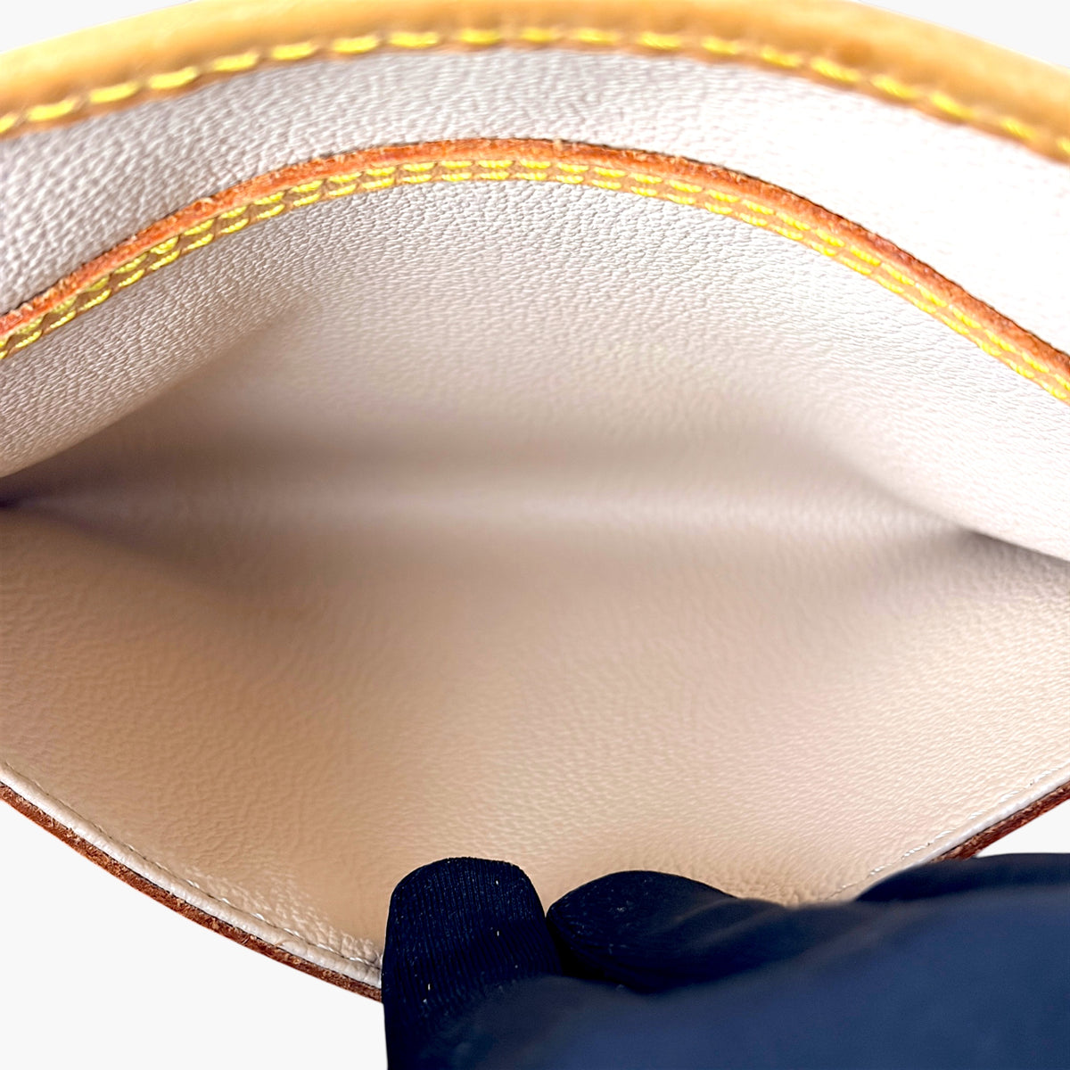 Beige leather-lined interior with tan piping on a monogram bucket bag