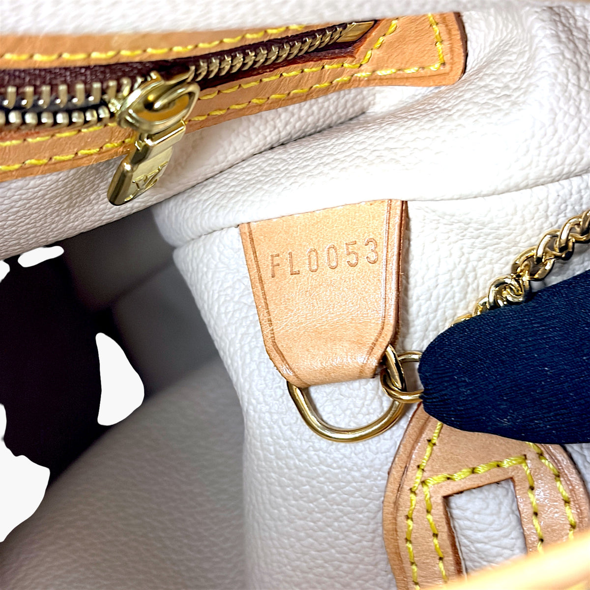 Monogram bucket bag interior with zipper, leather tab, and gold hardware