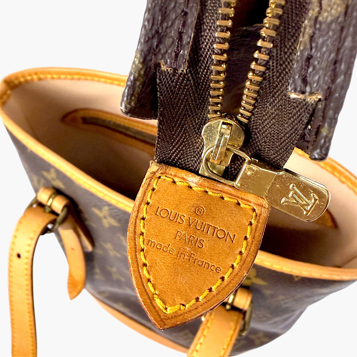 Bucket bag zipper pull with Louis Vuitton leather tag and gold hardware