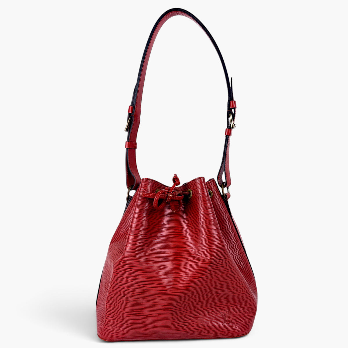 A red textured leather bucket bag with a drawstring closure and a single shoulder strap, photographed against a clean white background.