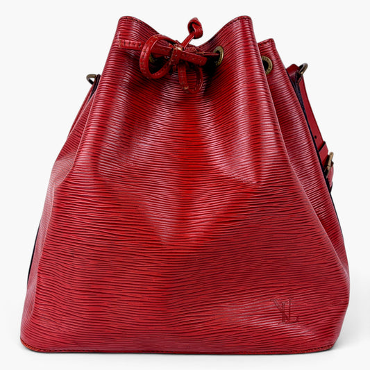A red textured leather drawstring bucket bag with a subtle embossed pattern, shown against a plain white background.