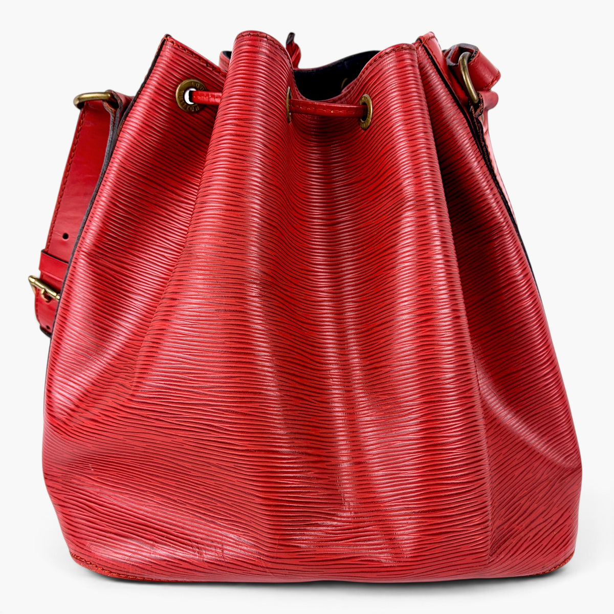 Red leather bucket bag front view with drawstring cords and gold-tone grommets