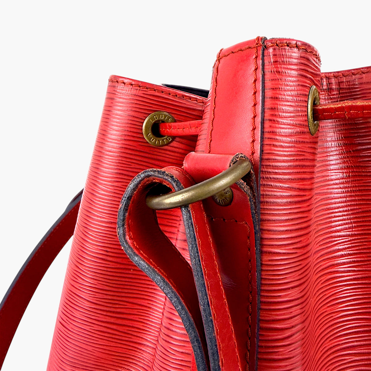 Red bucket bag front with drawstring cord and gold eyelet hardware