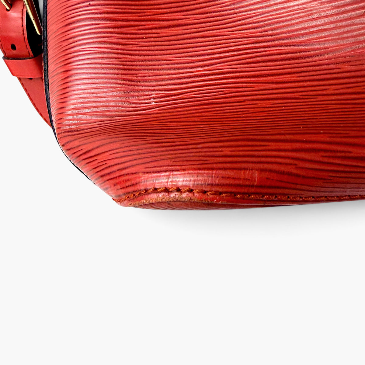 Red bucket bag base with ribbed Epi texture and visible edge stitching