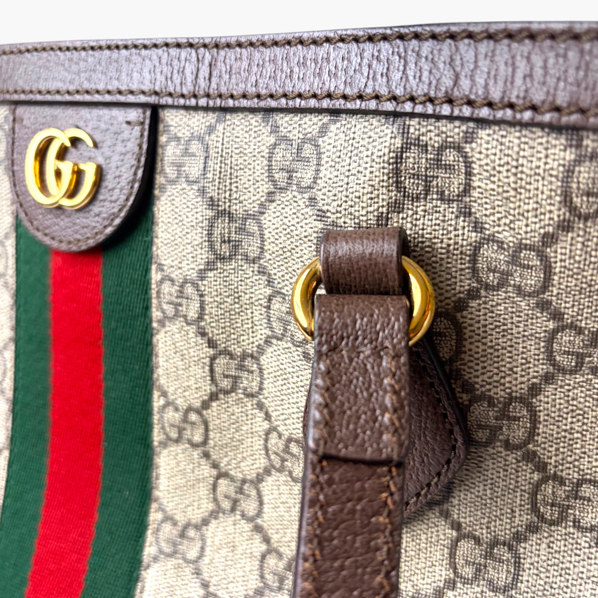Beige GG Supreme canvas tote corner with brown leather strap and gold-tone hardware