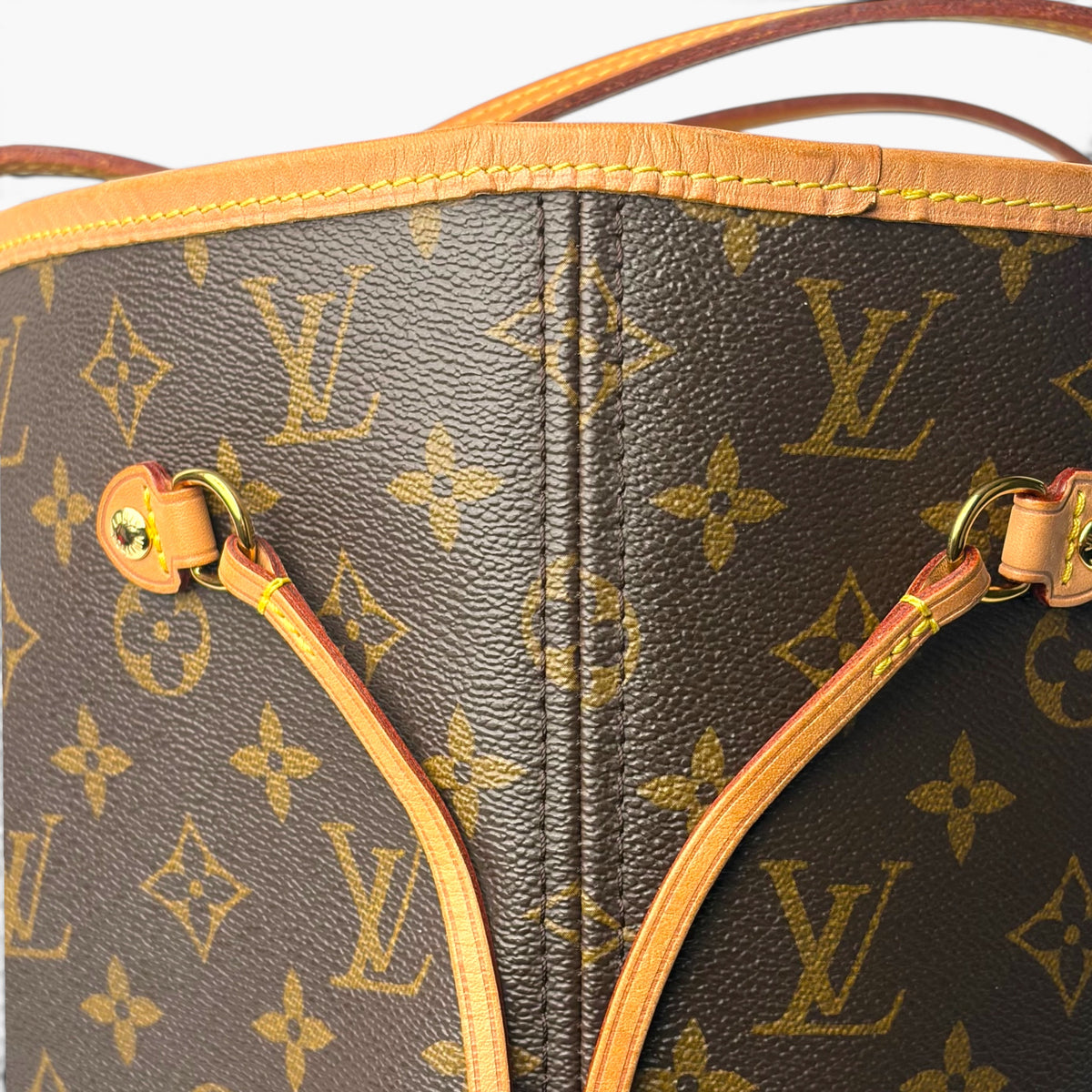 Monogram tote bag with tan top edge, front drawcord channel, and gold-tone rings
