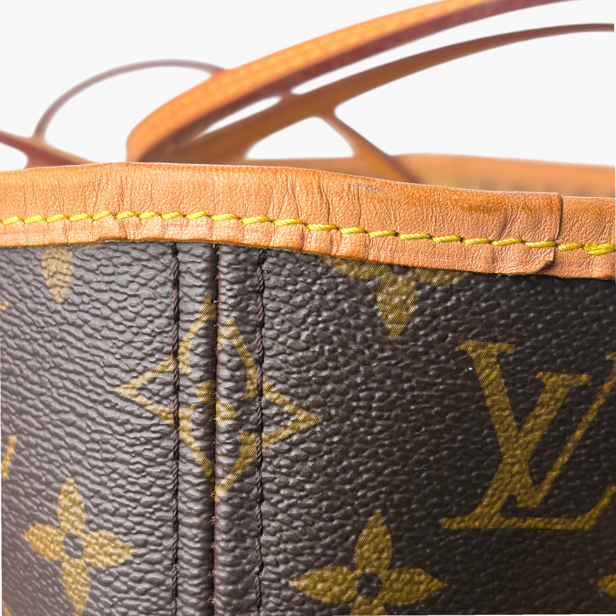 Monogram tote bag top edge with tan leather trim and central drawstring seam