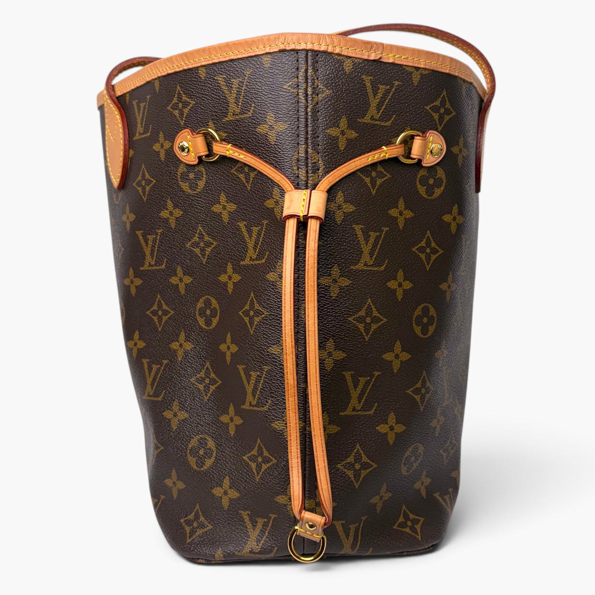 Monogram tote bag with tan leather trim, curved handles, and side drawstring pulls