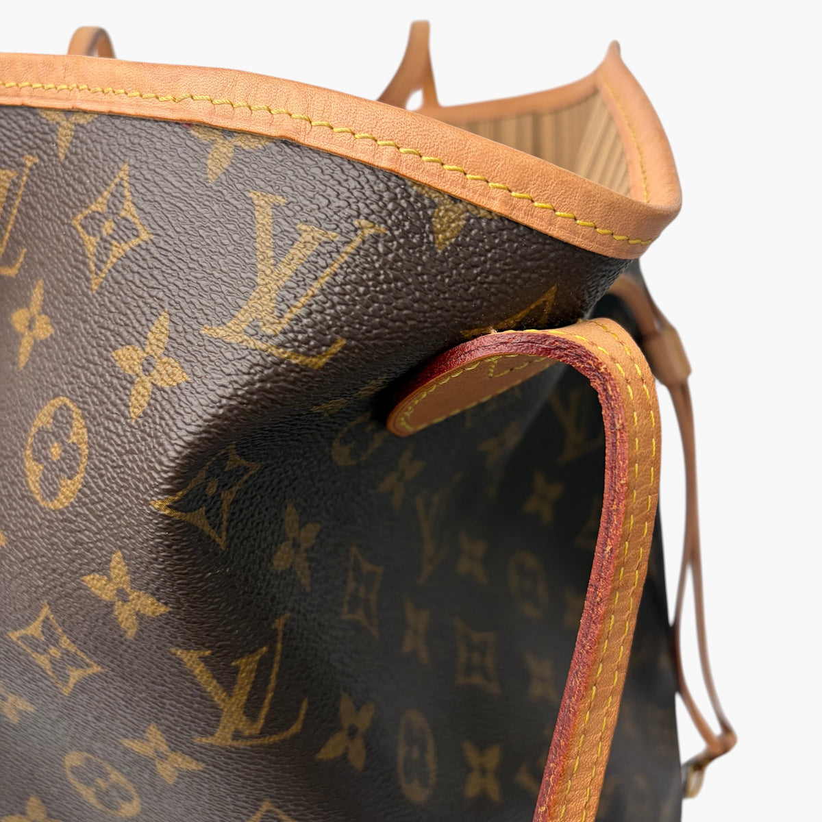 Brown monogram tote bag top edge with tan trim and open side panel