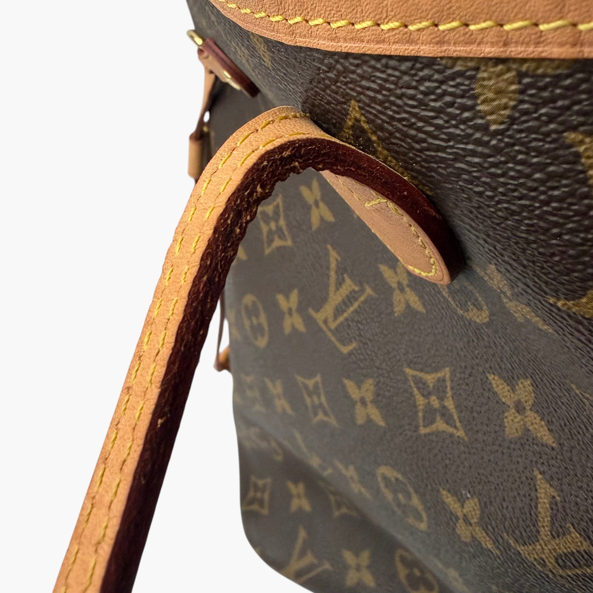 Brown monogram tote bag with tan leather loop and visible side strap attachment