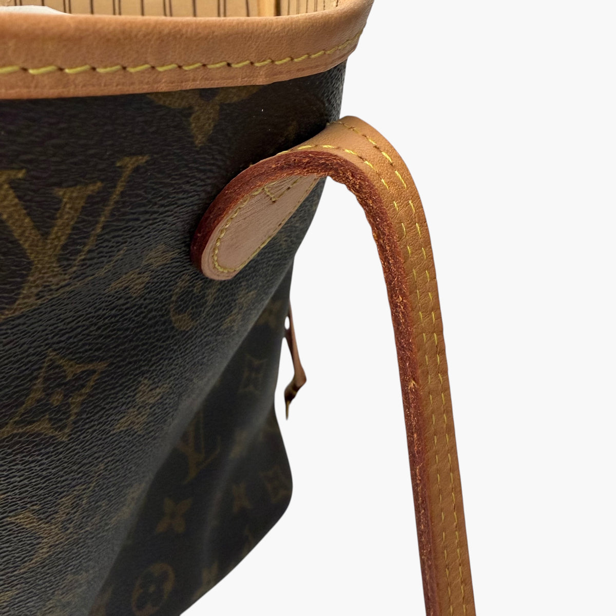 Brown monogram tote bag side with tan leather edge protector and loop detail