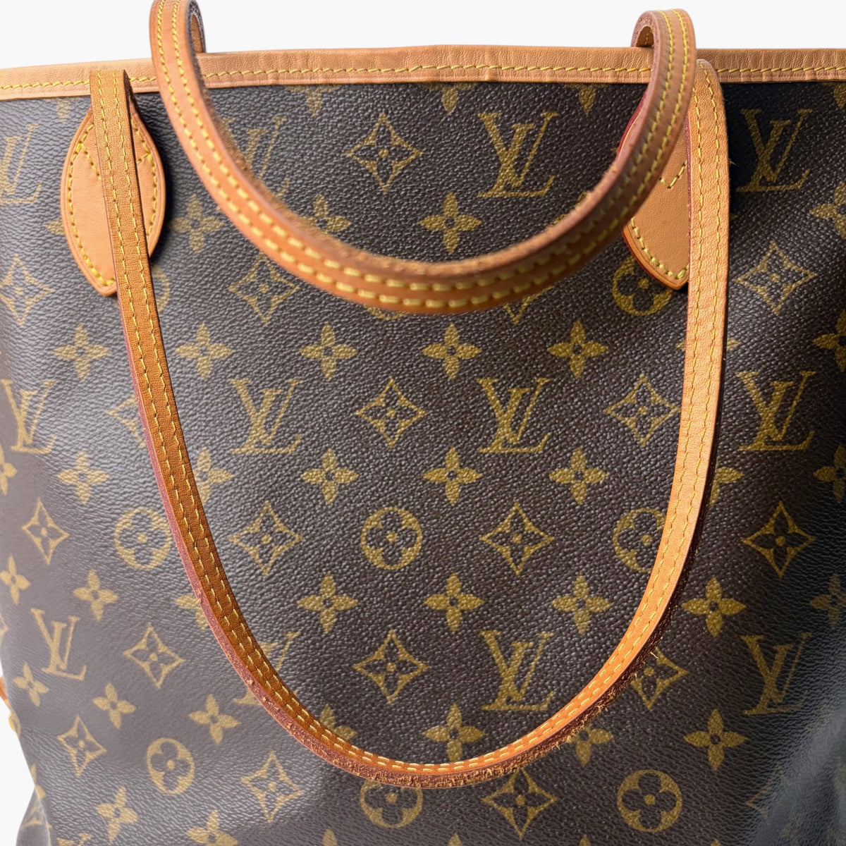 Brown monogram bag with tan leather handle piping and stitched strap detail