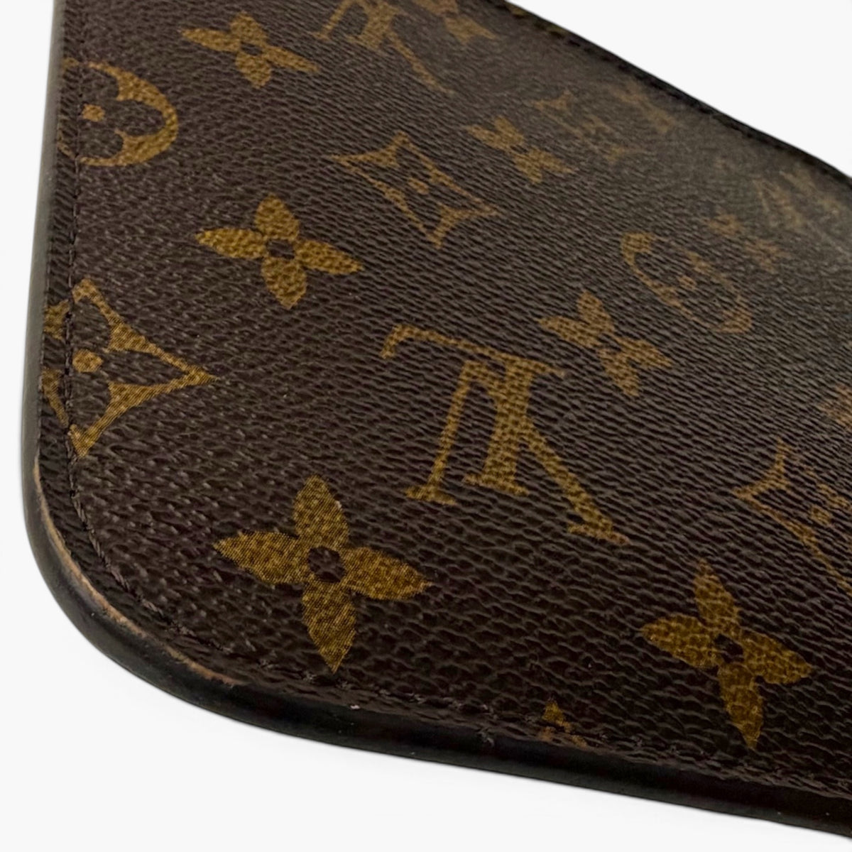Monogram canvas pouch corner with dark base and gold LV pattern details