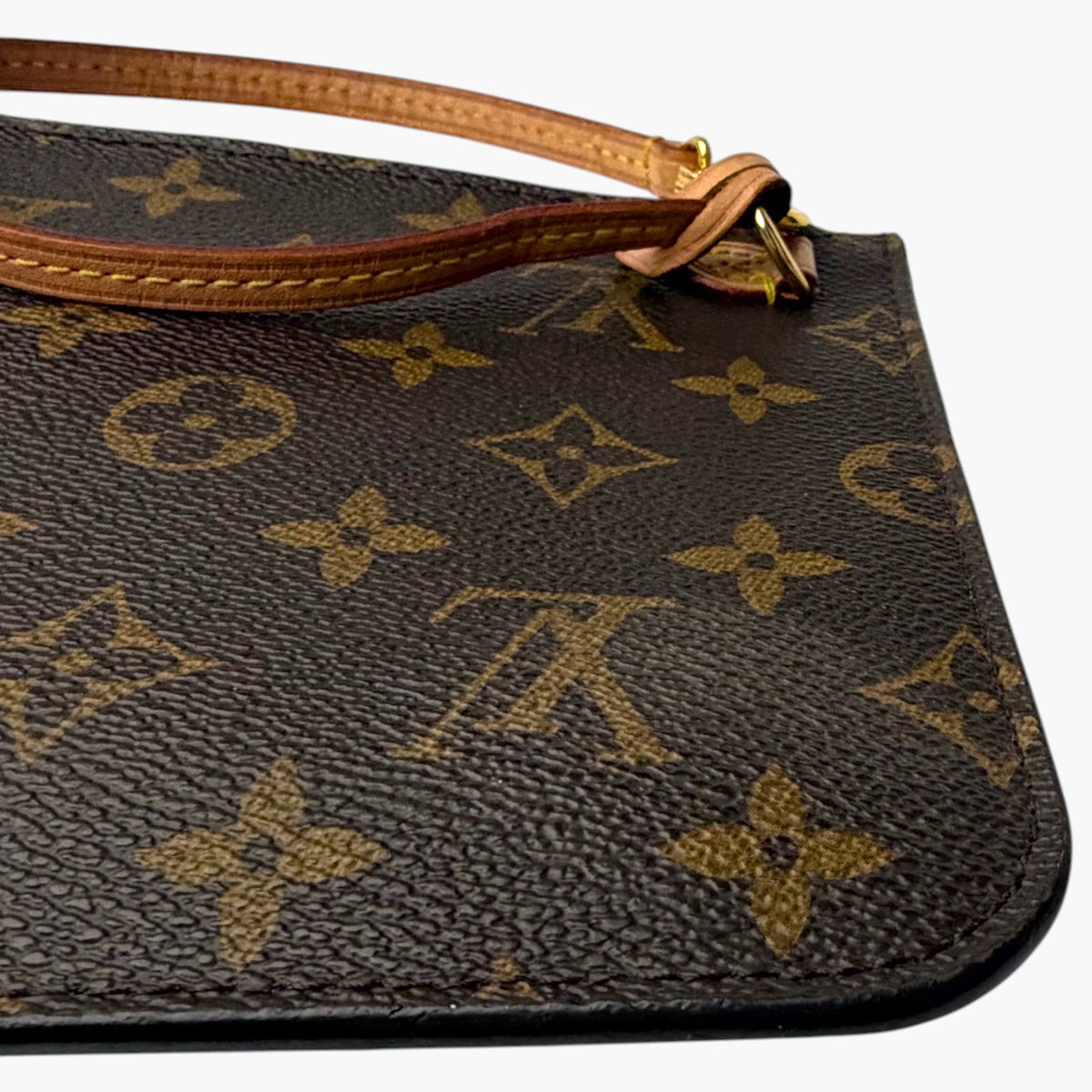 Monogram canvas wristlet with zipper pull and tan leather trim along edge