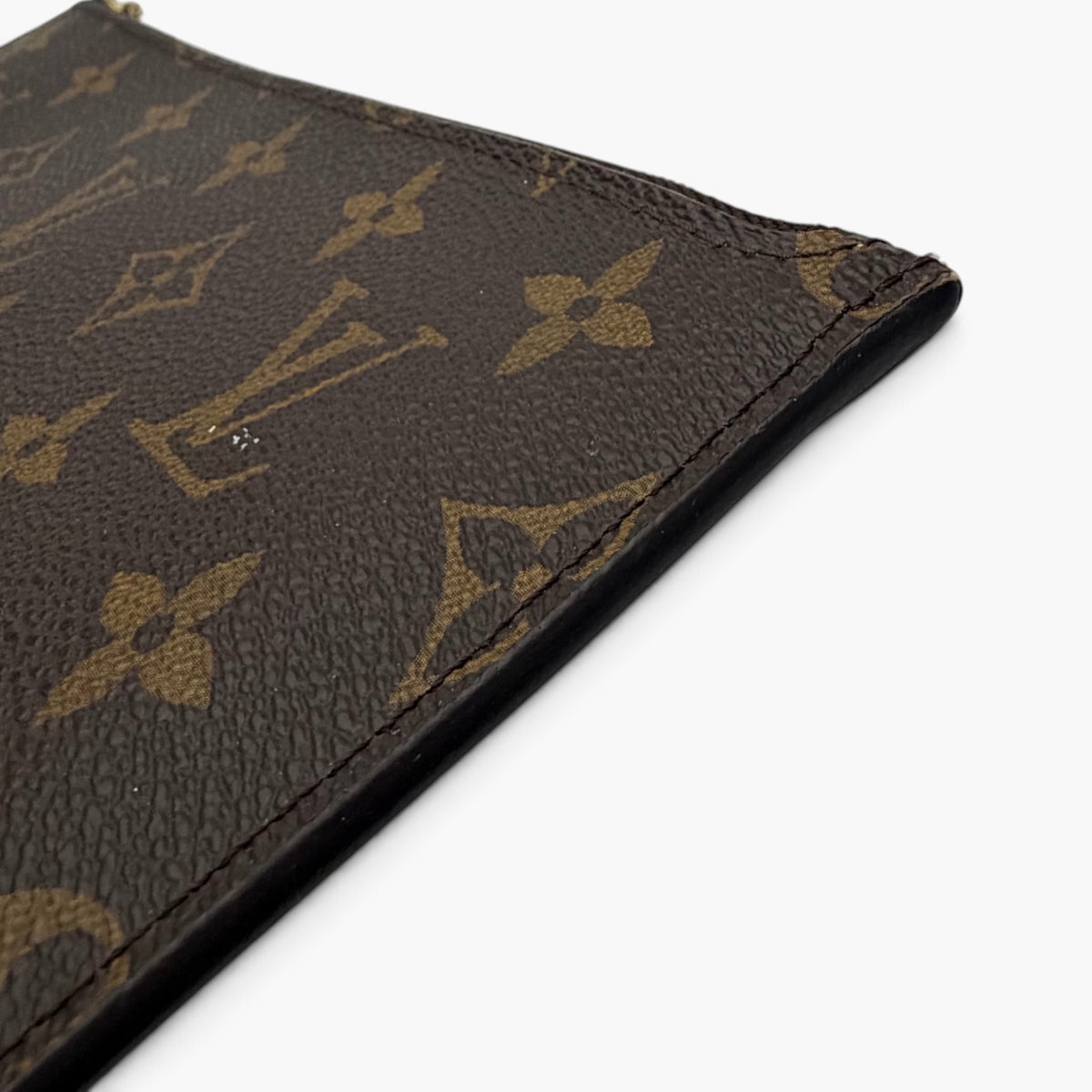 Monogram canvas corner seam with dark base and gold LV emblem pattern