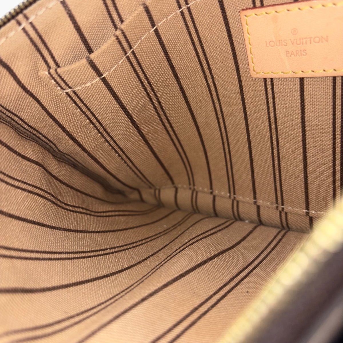 Interior lining with stitched ridges and Louis Vuitton Paris logo patch
