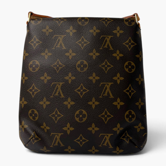 Monogram crossbody bag with long strap, dark exterior with repeating gold-style pattern