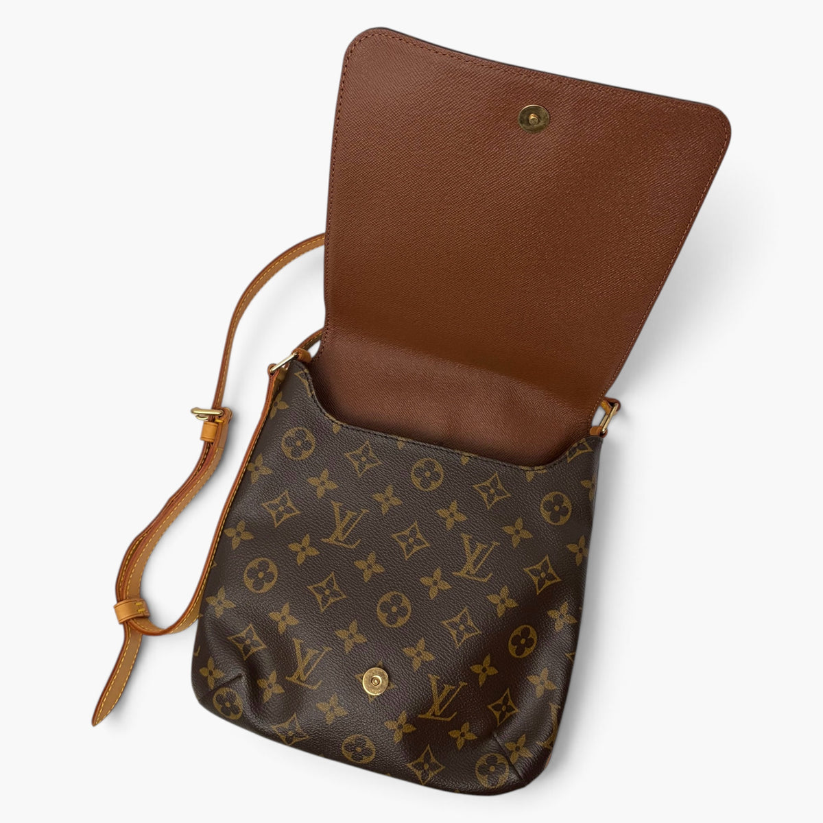 Crossbody bag with flap open, tan leather-like panel and dark monogram exterior