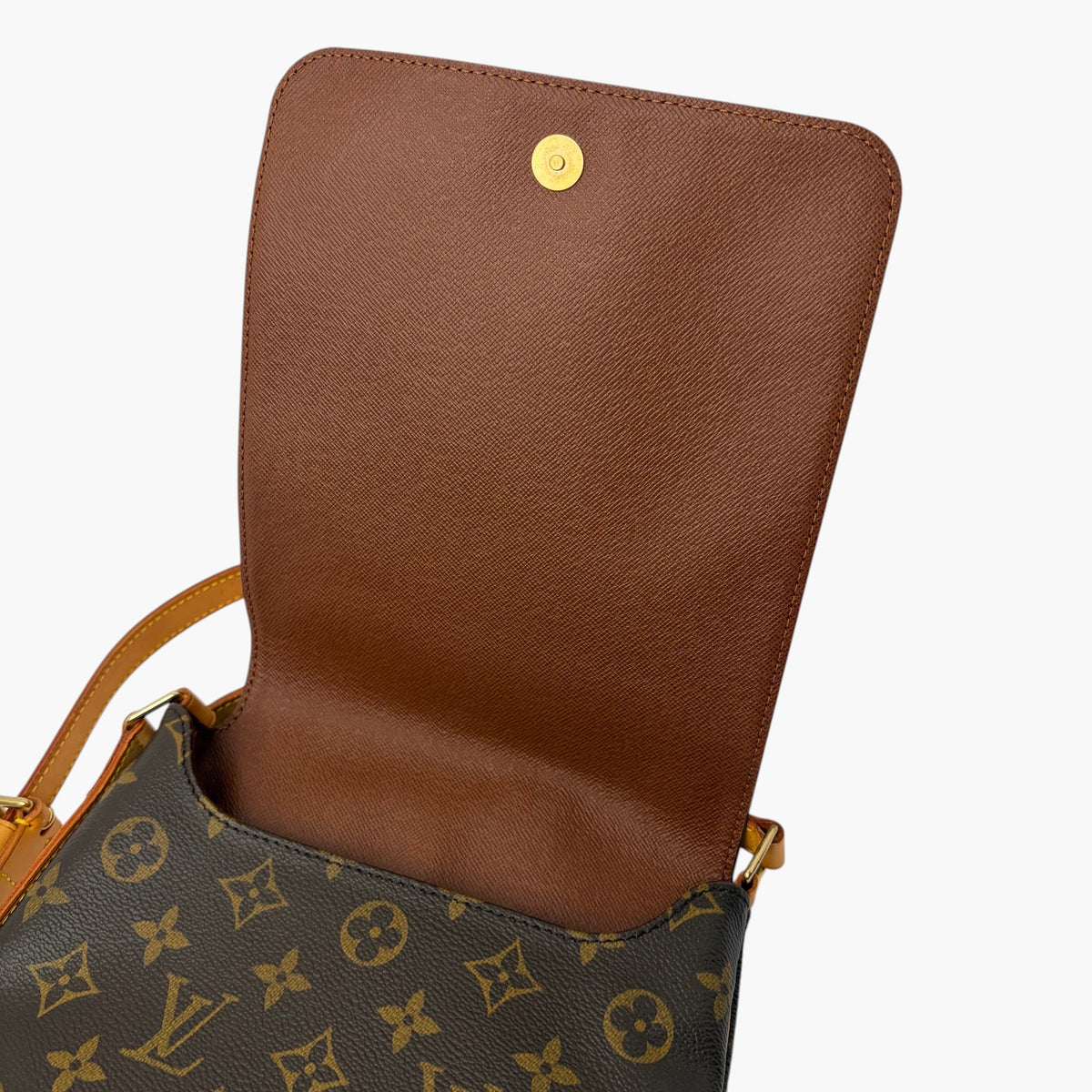 Crossbody bag with flip-top flap, tan panel and dark patterned body with strap hardware