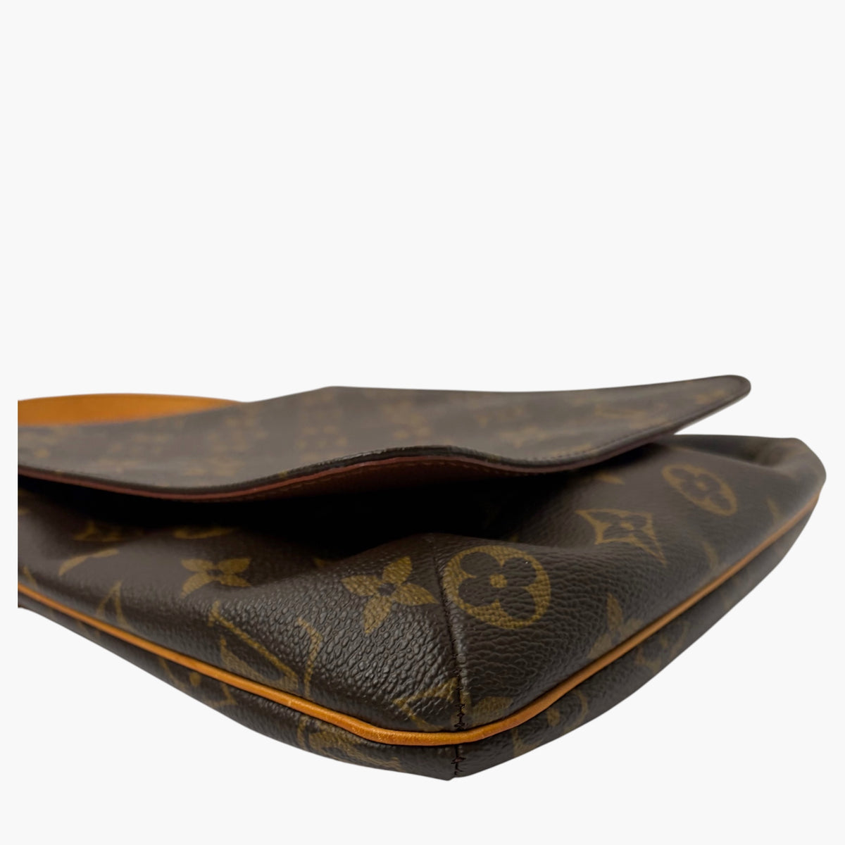 Monogram crossbody bag bottom corner view, dark exterior edge with tan piping