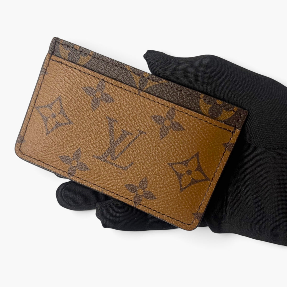 Brown monogram card holder with dark logo pattern and topstitched edges