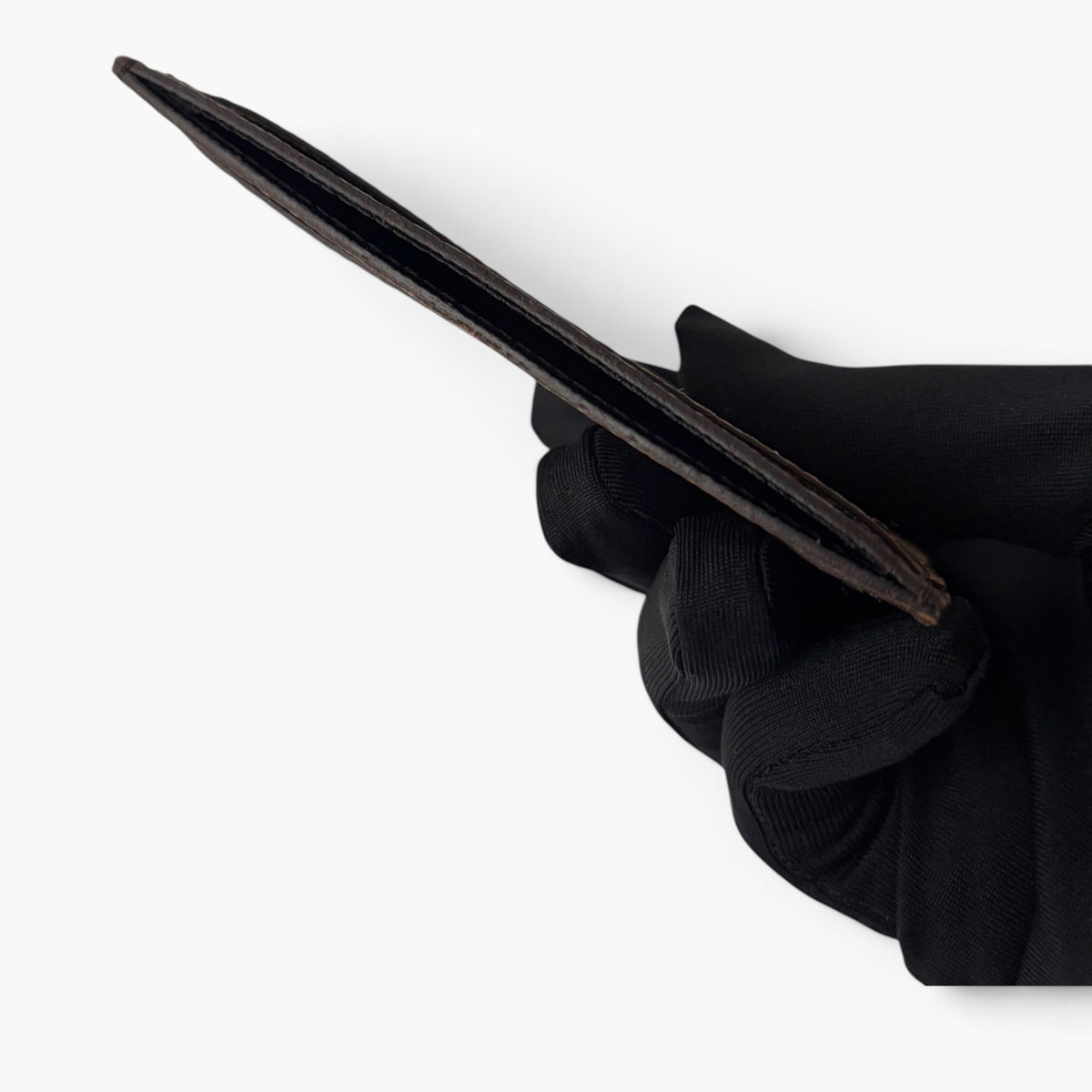 Monogram card holder end view with slim dark brown silhouette