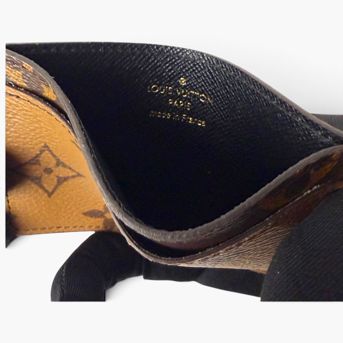 Reverse monogram card holder with dark interior lining and “Louis Vuitton” text