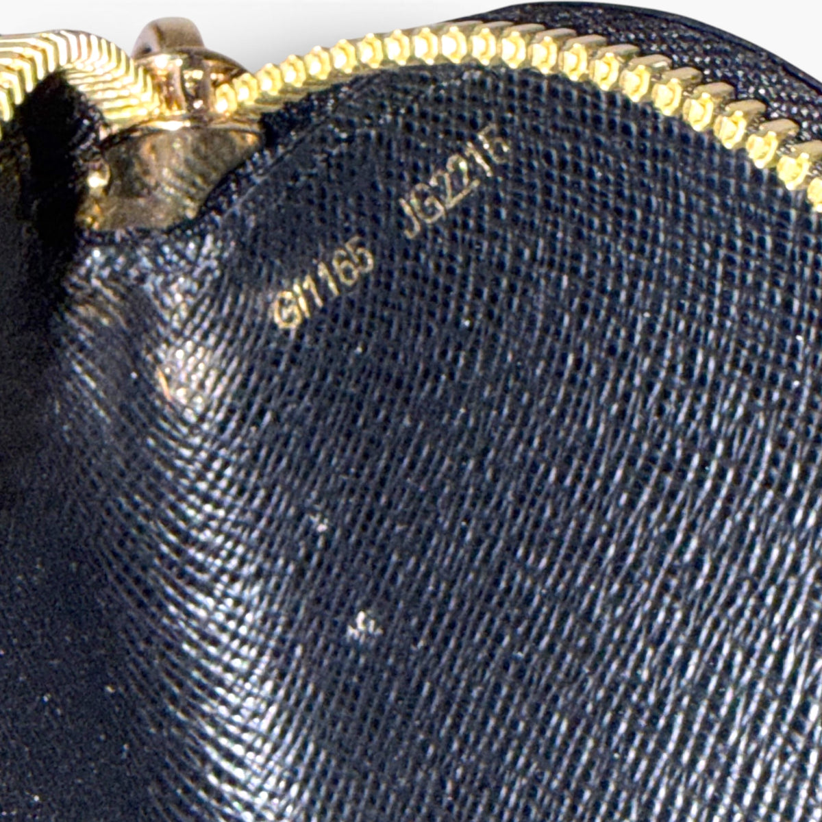 Dark blue monogram pencil case with gold-tone zipper and embossed logo pattern
