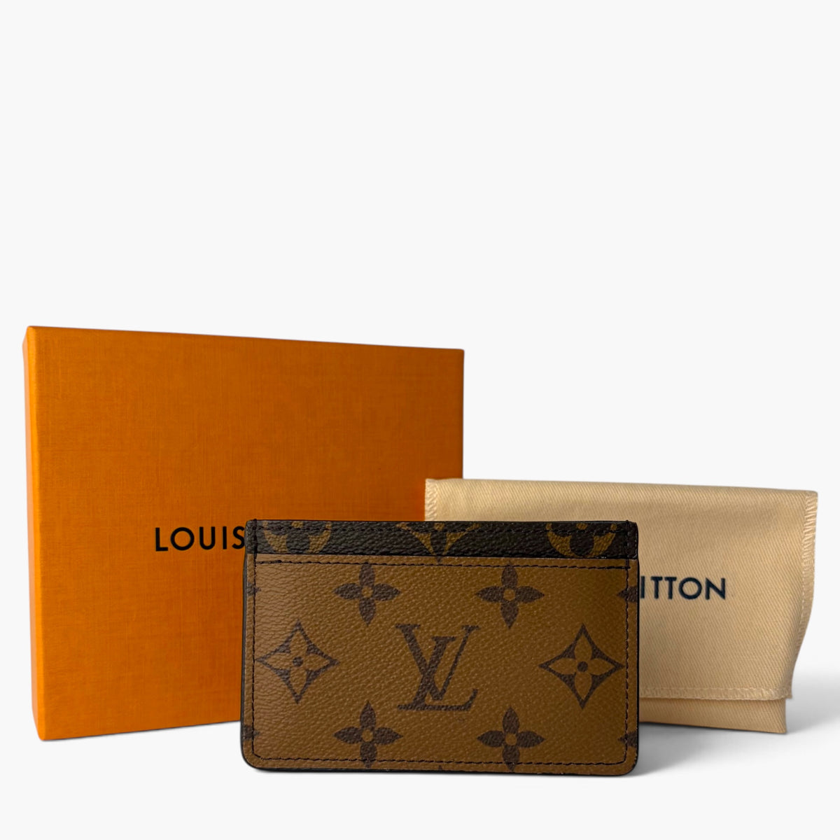 Monogram card holder shown with dust bags, brown front and reverse side