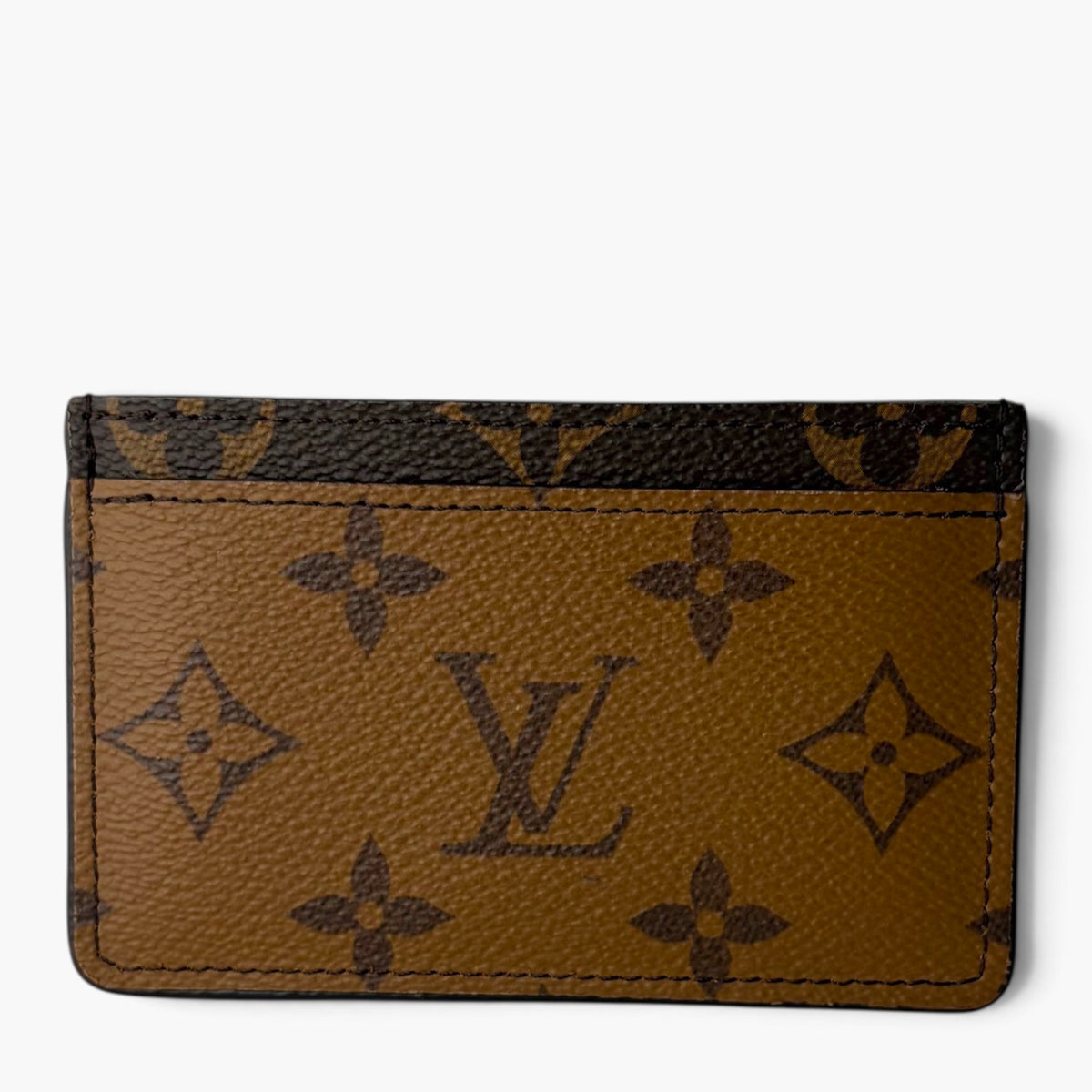 Brown monogram card holder with dark pattern and stitched card slots on front