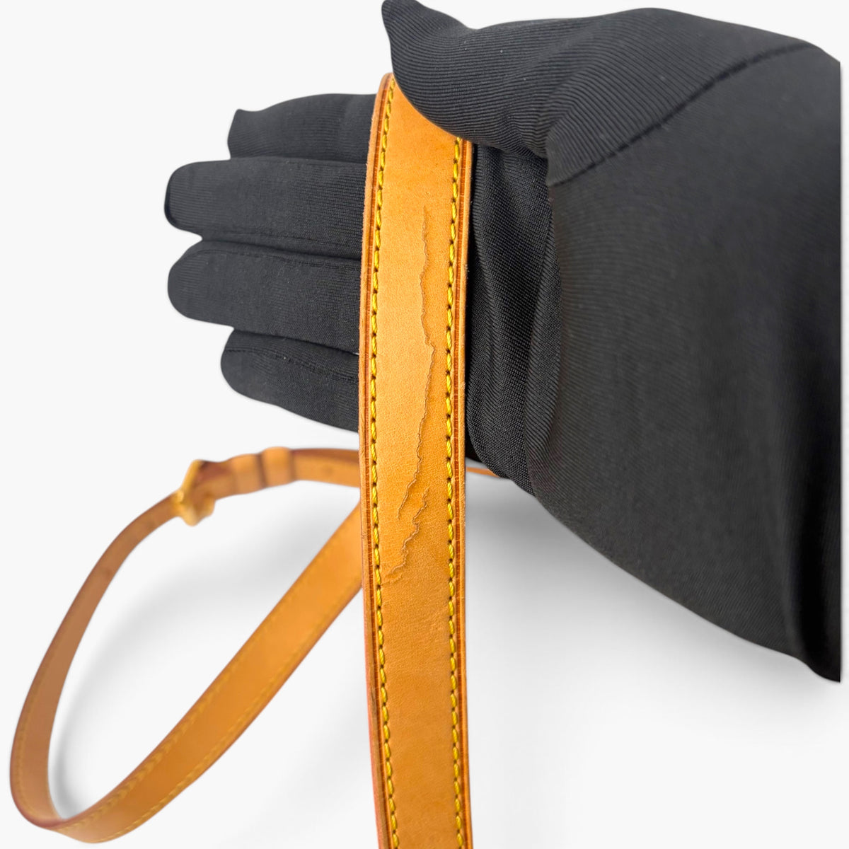 Adjustable leather shoulder strap with black fabric lining and orange stitching