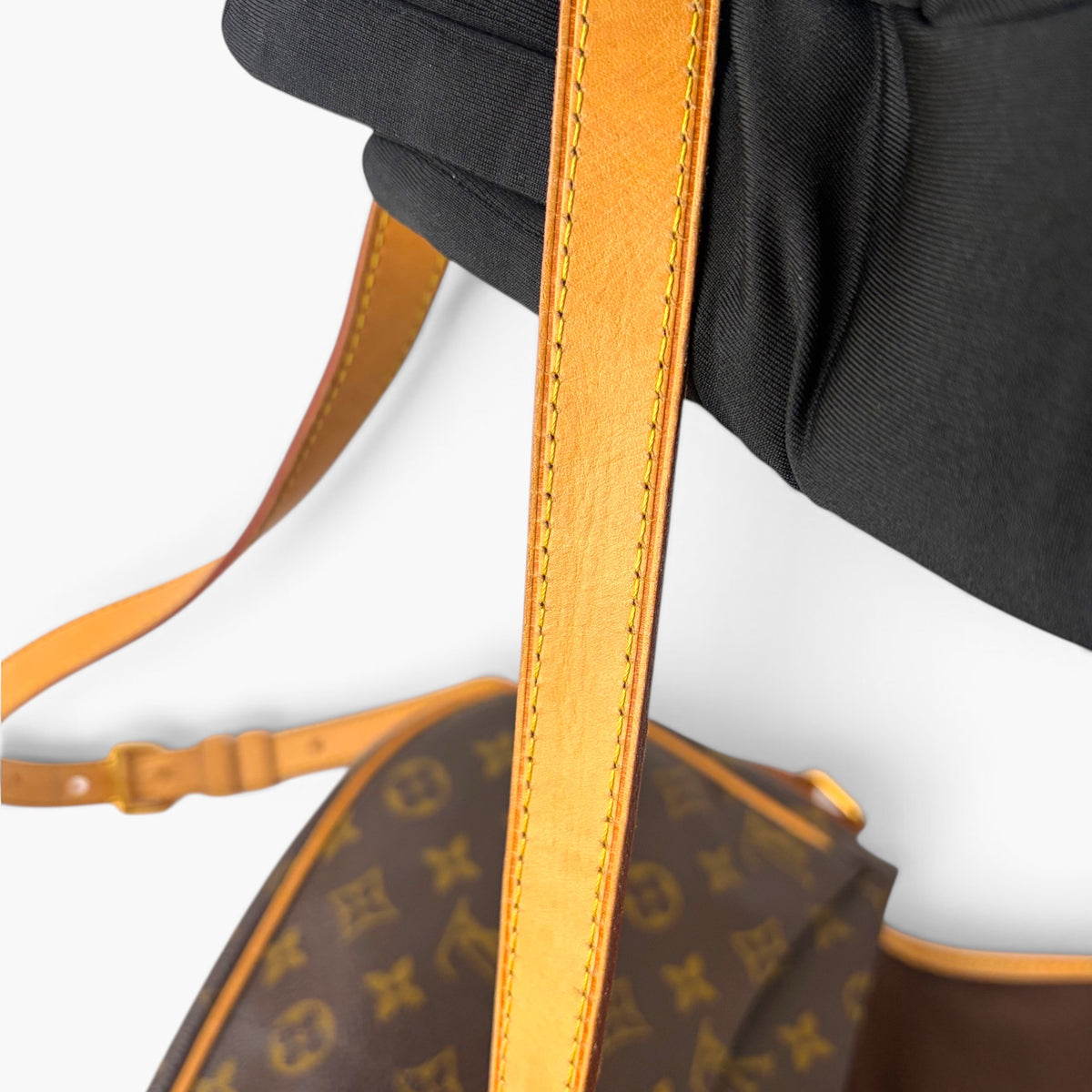 Orange leather strap panel with contrast stitching and monogram bag body edge