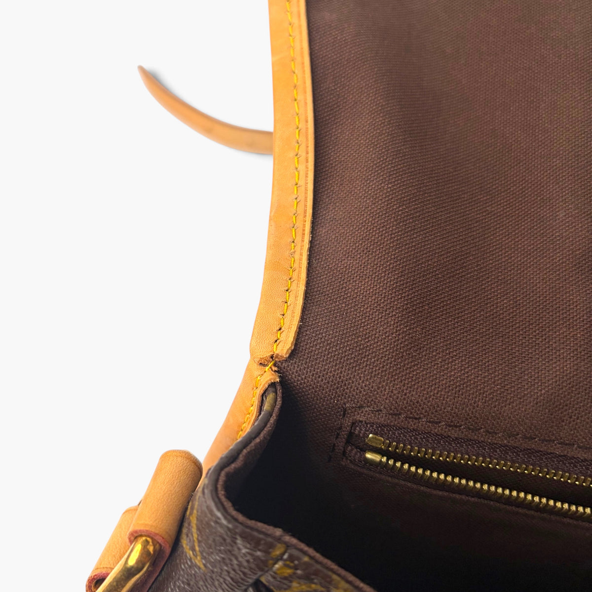 Close-up of brown lining and zipper with monogram canvas near leather trim