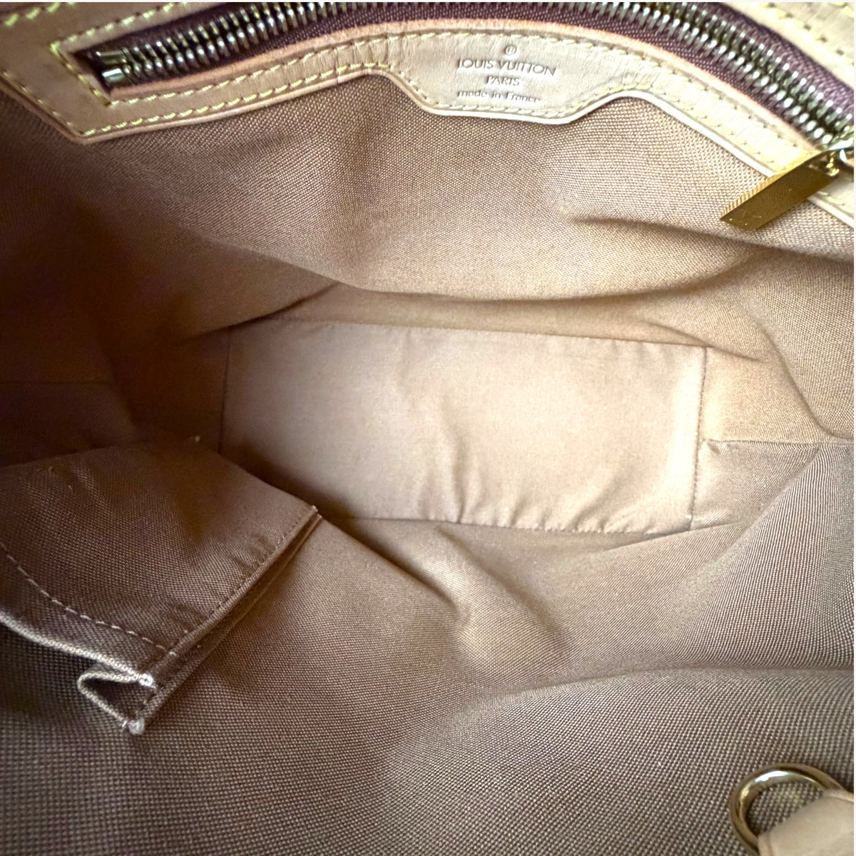 Monogram canvas tote interior with light beige lining and stitched pocket area