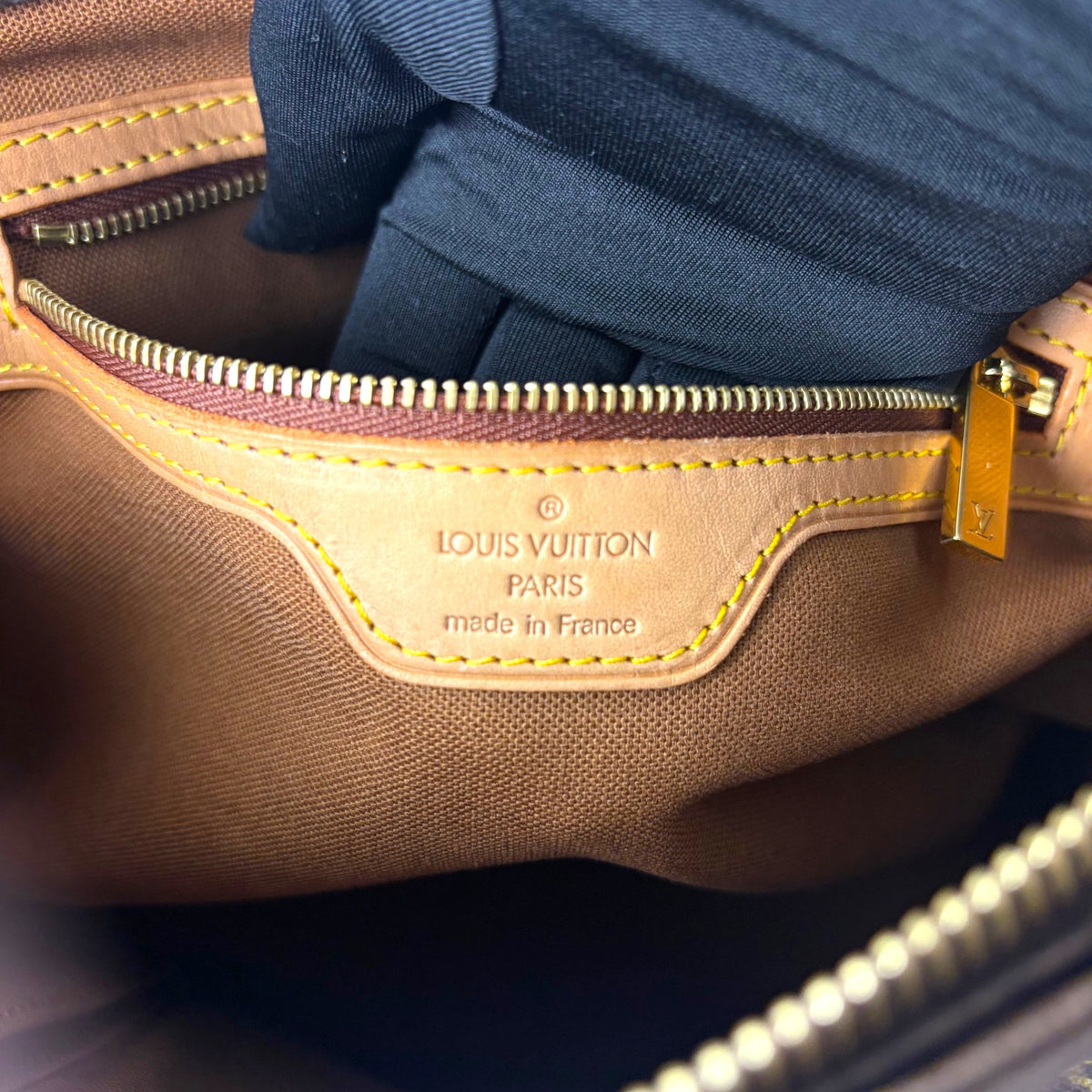 Louis Vuitton monogram canvas tote interior label with gold-tone zipper pull
