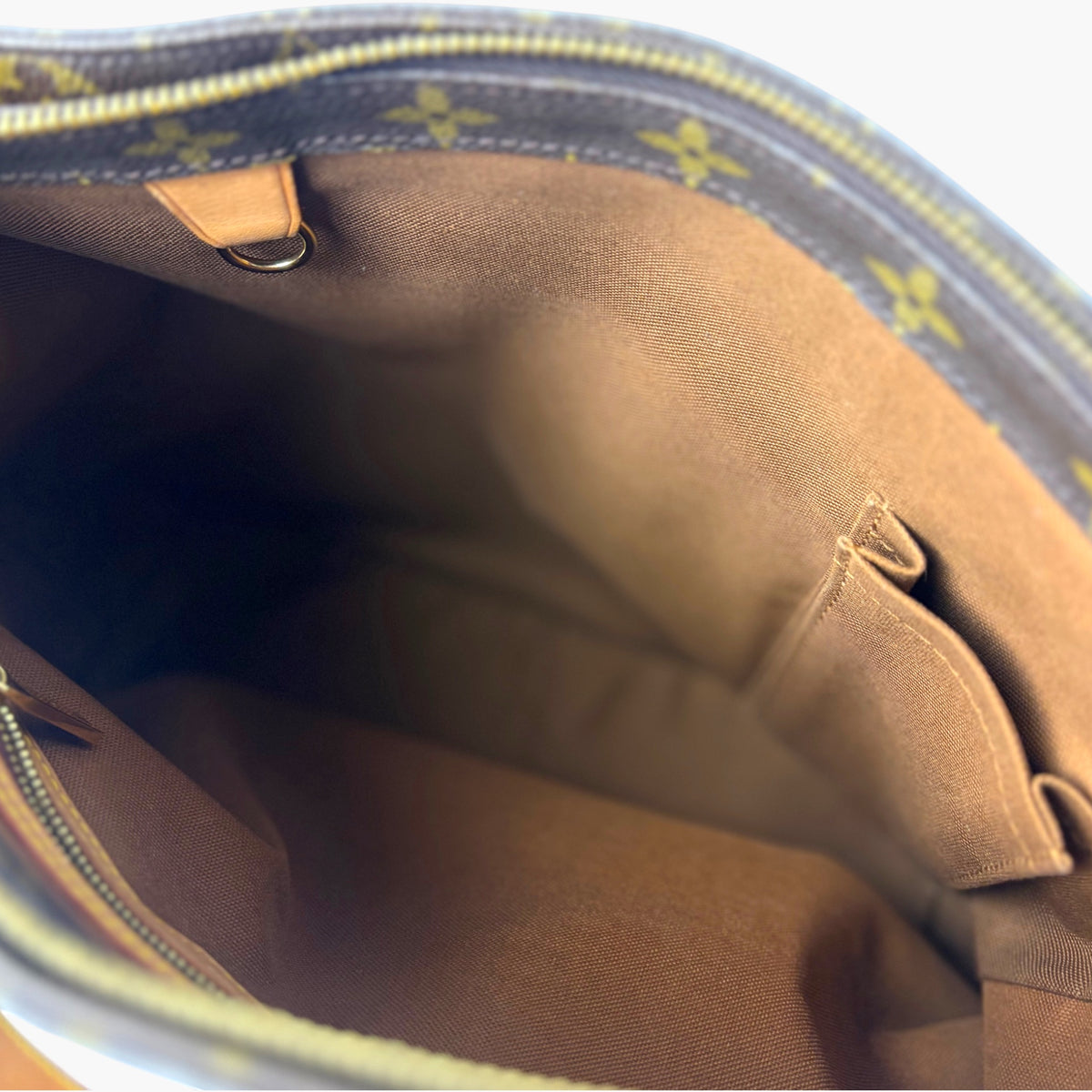 Monogram canvas tote interior with beige lining and stitched slip pocket