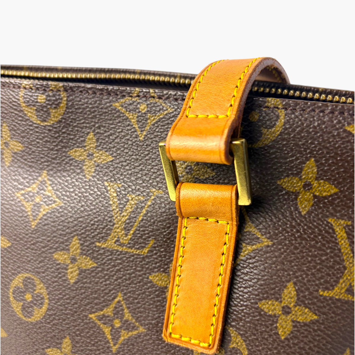 Monogram canvas tote side strap with orange leather trim and gold buckle
