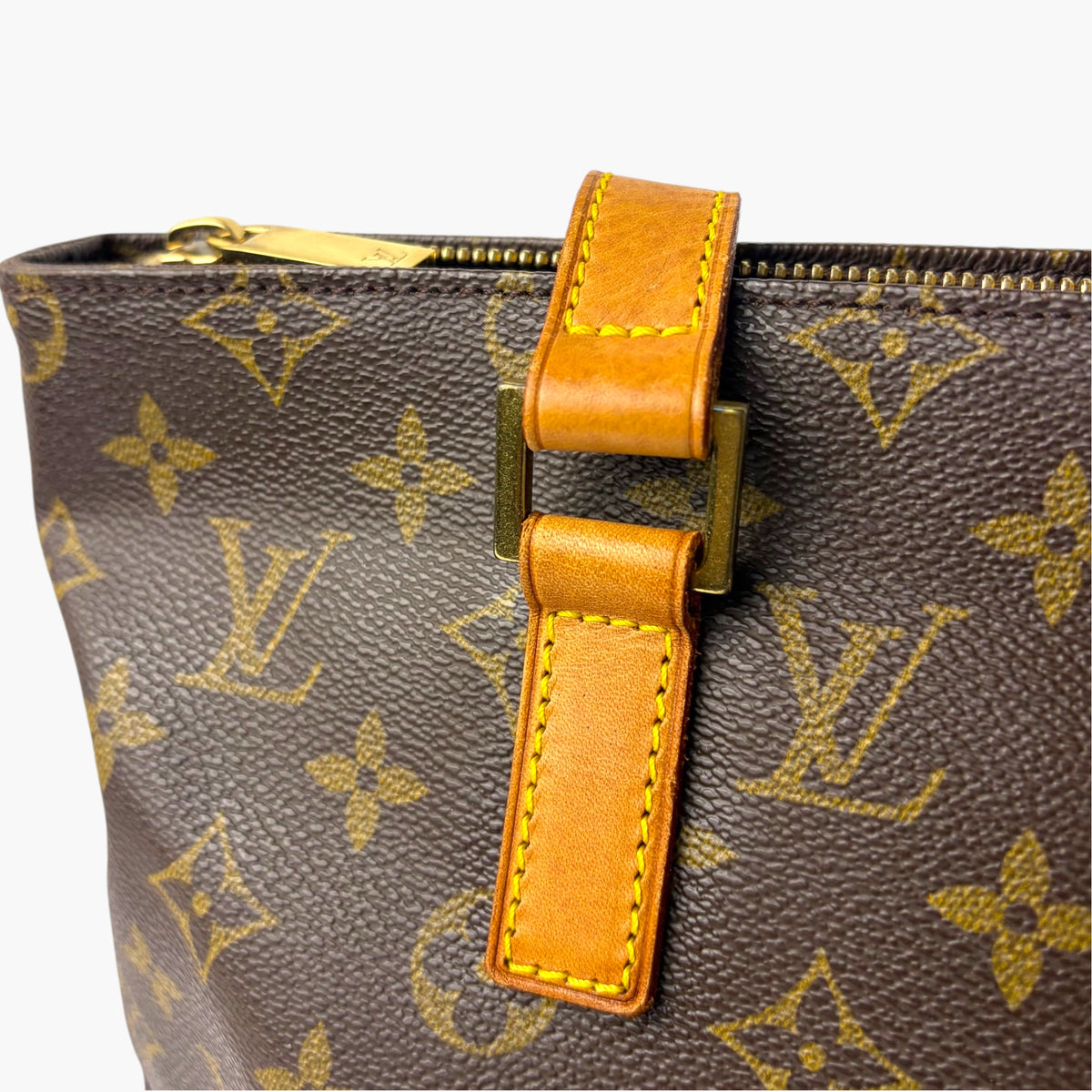 Monogram canvas tote front strap with orange leather tab and gold clasp
