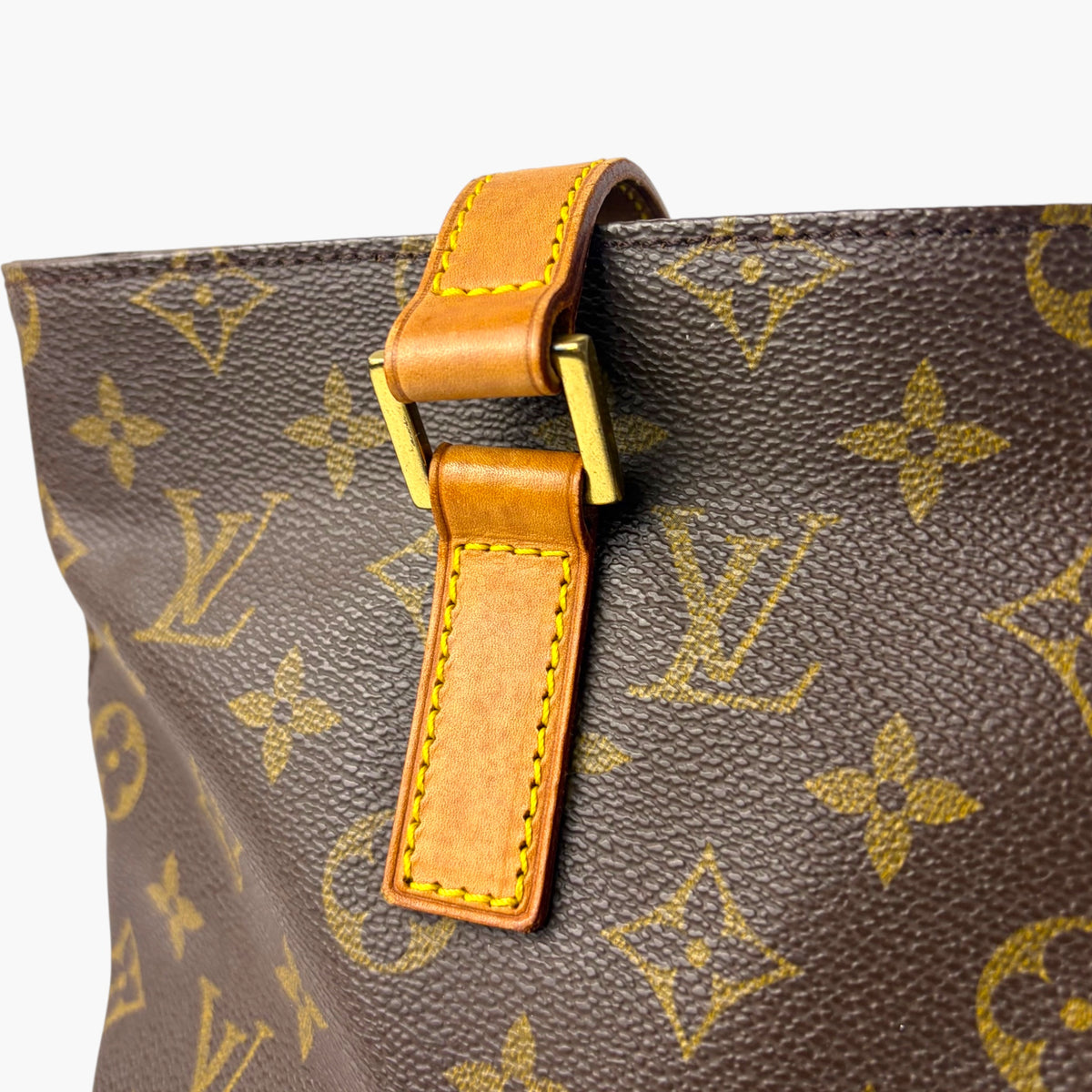 Monogram canvas tote strap attachment with orange leather tab and gold hardware