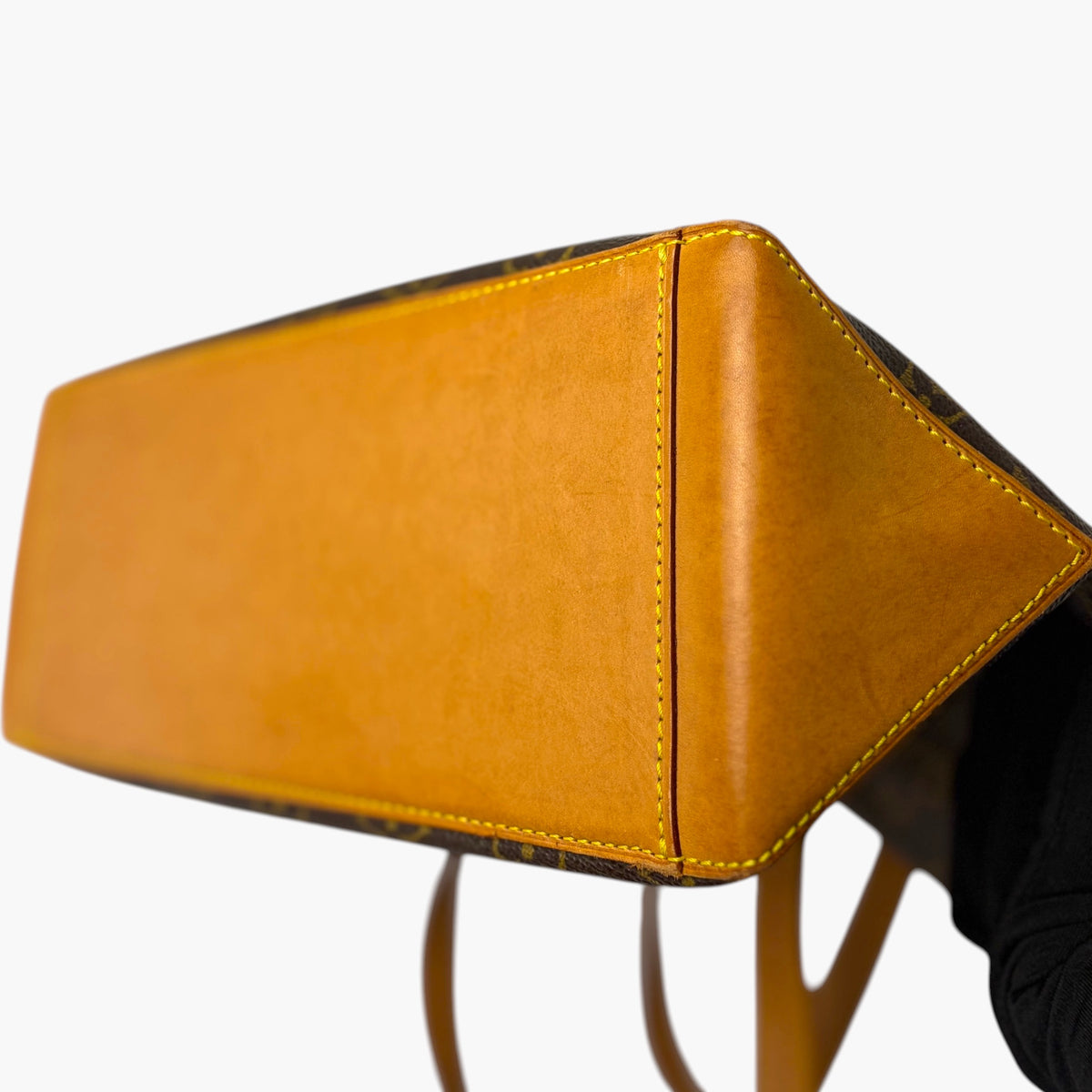 Orange leather base panel with yellow-orange stitching on a tote bag