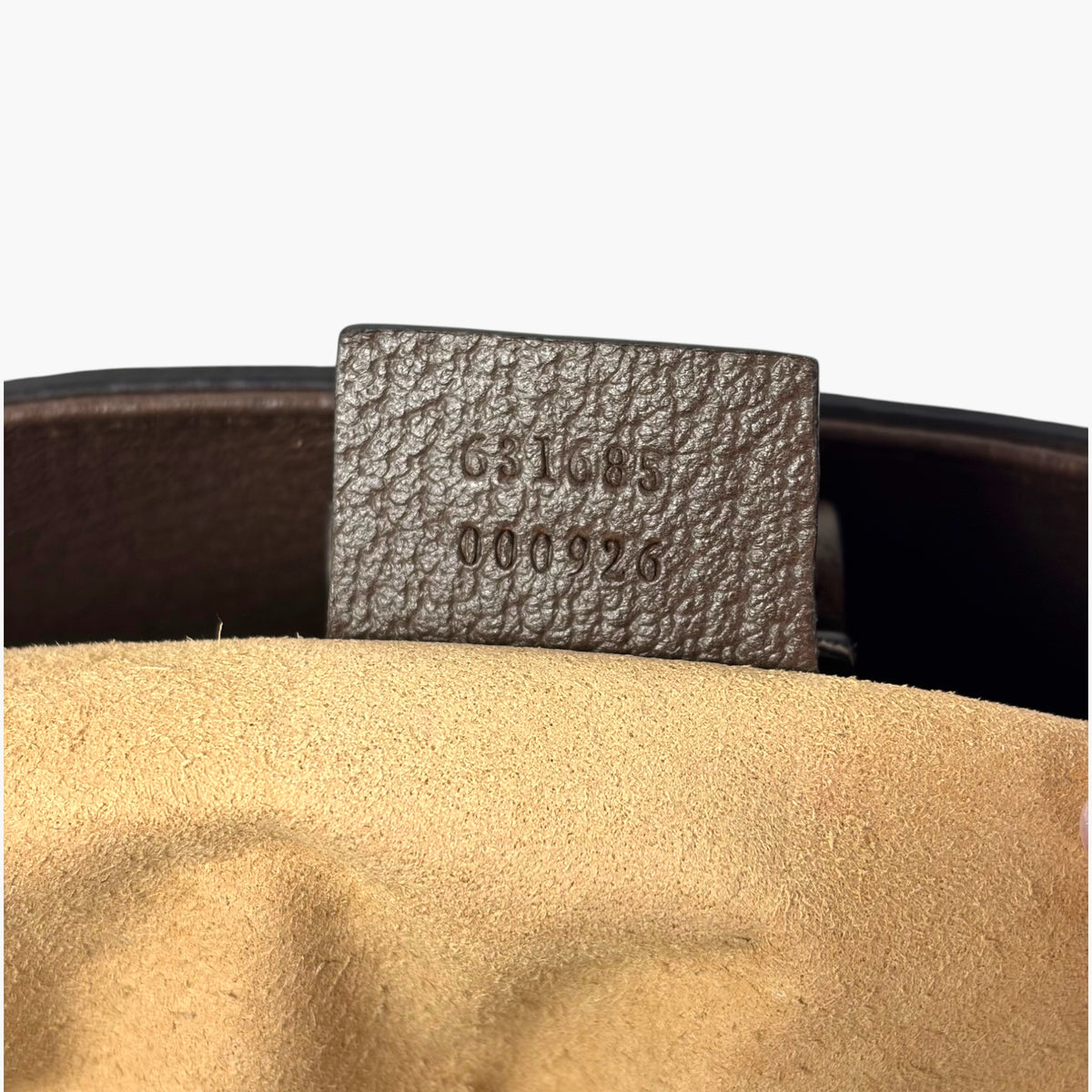 Tote interior leather label with embossed serial text and dark lining
