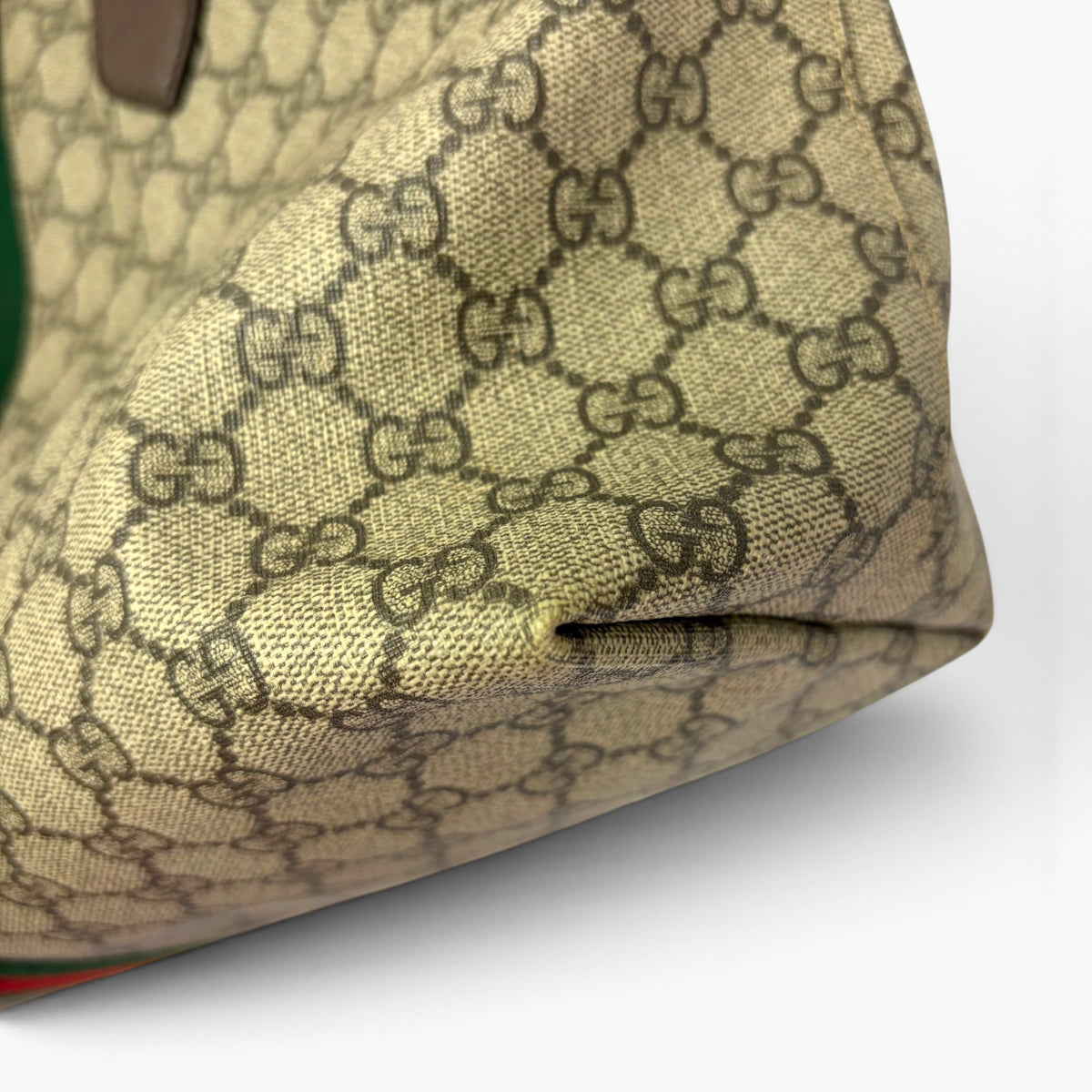 Beige GG Supreme canvas side with subtle pattern texture and dark brown leather patch