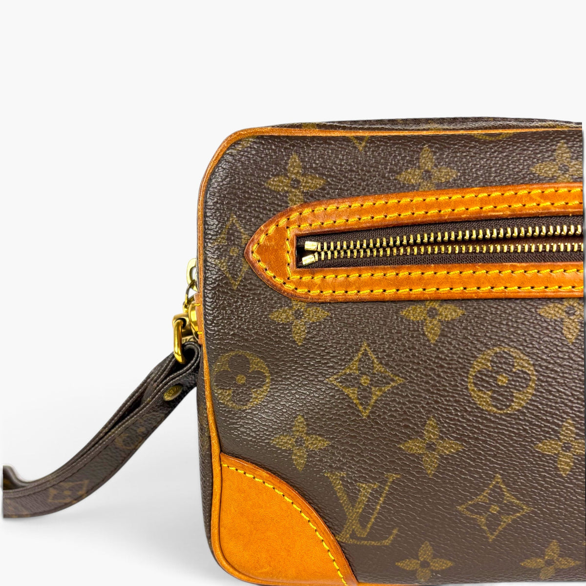 Monogram pouch angled close-up with top zip and side leather panel
