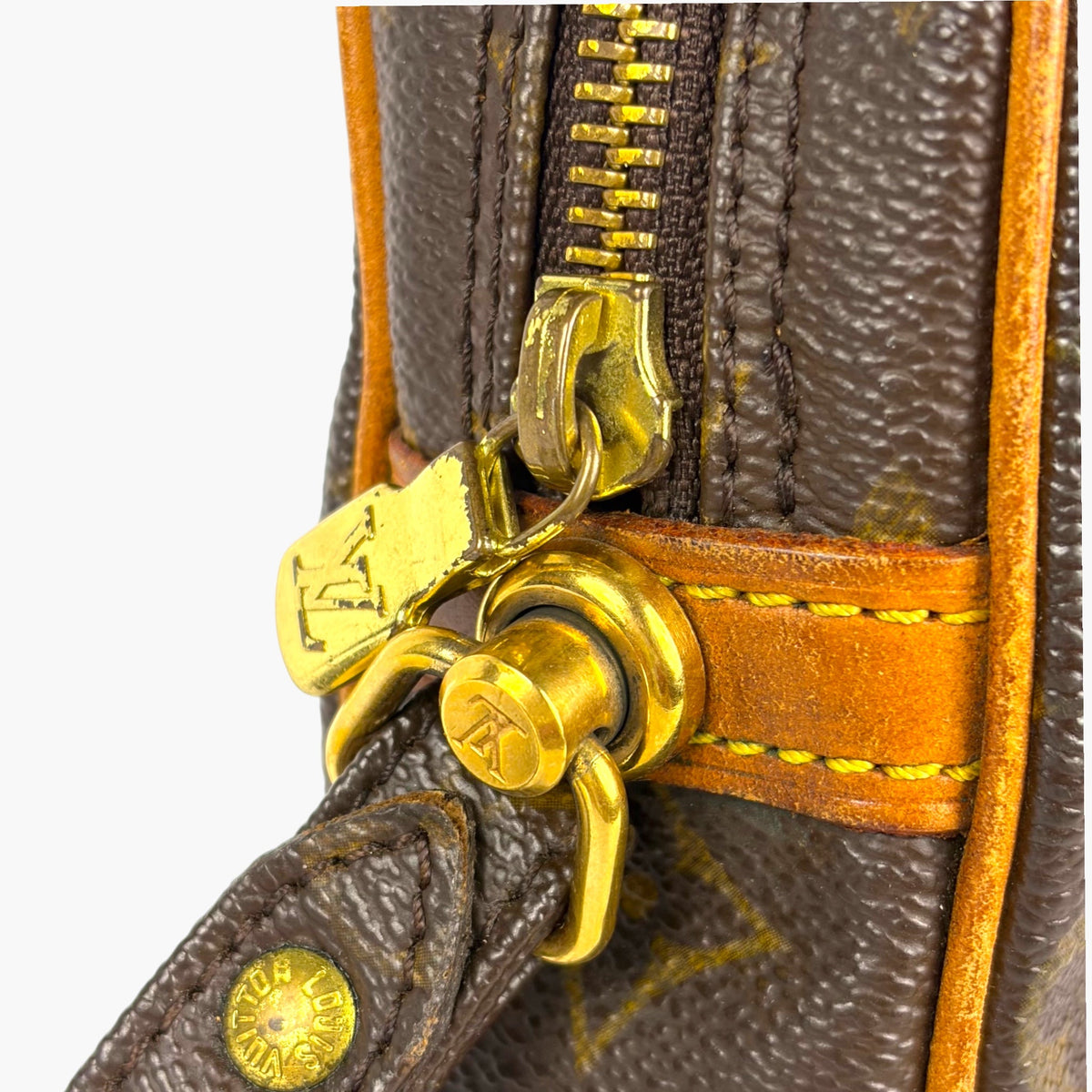 Gold clasp and keyring detail on monogram pouch with orange strap