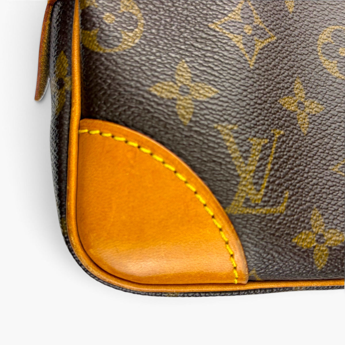 Monogram canvas pouch with tan leather corner panel and contrast stitching