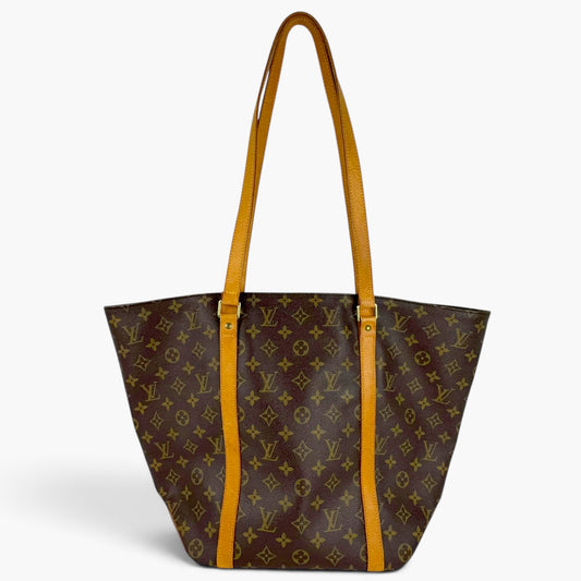 Brown monogram tote bag with yellow handles, open top, and side panels