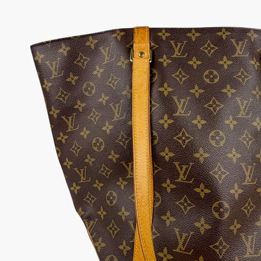 Brown monogram shopping tote bag with tan leather strap and gold hardware