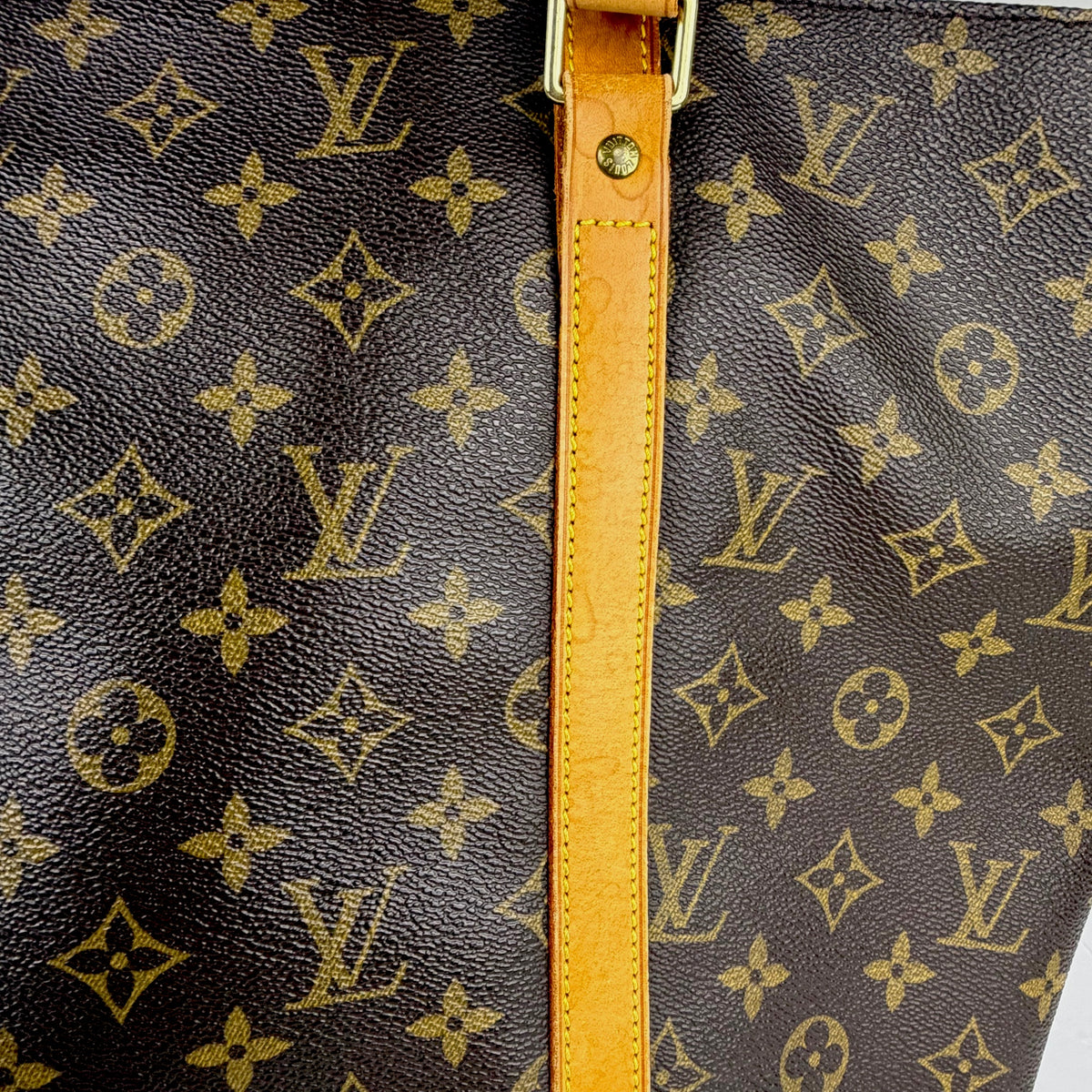 Close-up of brown monogram tote fabric with tan strap and stitching