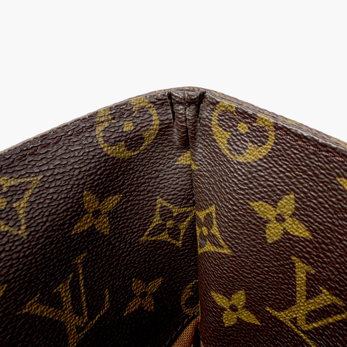 Brown monogram canvas close-up with textured grain and stitched center seam